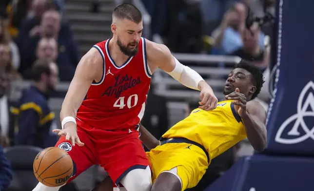 Indiana Pacers center Thomas Bryant (3) appears top draw the charge from LA Clippers center Ivica Zubac (40) during the first half of an NBA basketball game in Indianapolis, Sunday, Feb. 23, 2025. (AP Photo/Michael Conroy)