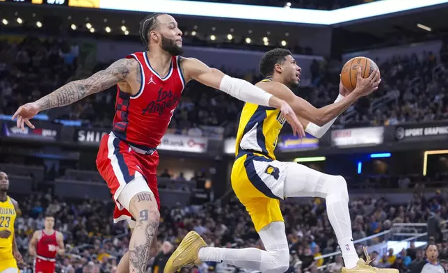 Indiana Pacers guard Tyrese Haliburton (0) shoots in front of LA Clippers guard Amir Coffey (7) during the first half of an NBA basketball game in Indianapolis, Sunday, Feb. 23, 2025. (AP Photo/Michael Conroy)