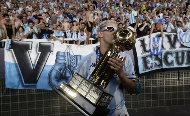 Gaston Martirena of Argentina's Racing Club celebrates with the Recopa Sudamericana trophy after beating Brazil's Botafogo in the final soccer match, in Rio de Janeiro, Thursday, Feb. 27, 2025. (AP Photo/Bruna Prado)