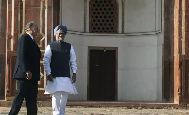 FILE - Indian Prime Minister Manmohan Singh, right, walks with the Aga Khan, spiritual head of Ismaili Muslims, as he arrives to inaugurate the restored 16th Century Humayun's Tomb in New Delhi, India, Wednesday, Sept. 18, 2013. (AP Photo/Manish Swarup, File)