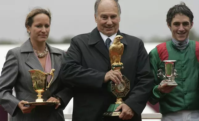FILE - The owner of Zarkava his highness Aga Khan, center, his daughter Zahra Aga Khan, left, and French jockey Christophe Soumillon hold their trophies after winning the Prix de l'Arc de Triomphe horse race at Longchamp race track in Paris, Sunday, Oct. 5, 2008. (AP Photo/Michel Euler, File)
