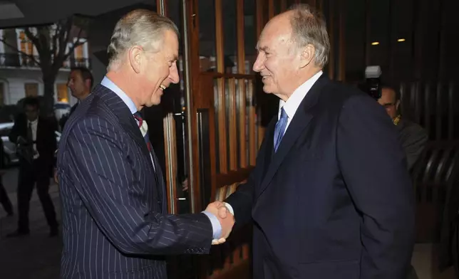 FILE - The Prince of Wales, now King Charles III, is greeted by the Aga Khan, right, during a visit to the Ismaili Centre to join a reception to help celebrate their 25th anniversary, in London, Nov. 18, 2010. (Anthony Devlin/PA via AP, File)