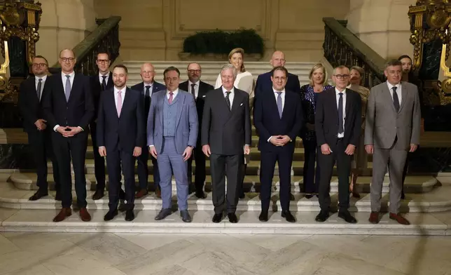 Belgium's King Philippe, center front, and new Belgian Prime Minister Bart De Wever, front center left, pose with ministers after a swearing in ceremony for the new government at the Royal Palace in Brussels, Monday, Feb. 3, 2025. (AP Photo/Omar Havana)