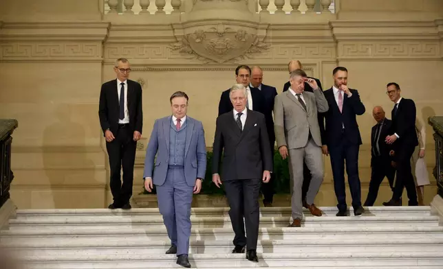 Belgium's King Philippe, center front, and new Belgian Prime Minister Bart De Wever, front center left, walk with ministers after a swearing in ceremony for the new government at the Royal Palace in Brussels, Monday, Feb. 3, 2025. (AP Photo/Omar Havana)
