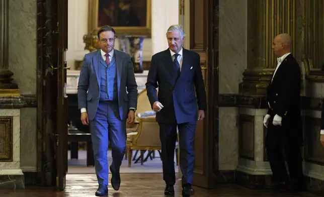 New Belgian Prime Minister Bart De Wever, left, walks with Belgium's King Philippe, center, during a swearing in ceremony for the new government at the Royal Palace in Brussels, Monday, Feb. 3, 2025. (AP Photo/Omar Havana)