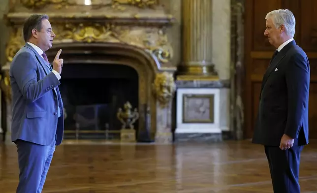 New Belgian Prime Minister Bart De Wever, left, raises his hand to take an oath during a swearing in ceremony for the new government in front of Belgium's King Philippe at the Royal Palace in Brussels, Monday, Feb. 3, 2025. (AP Photo/Omar Havana)