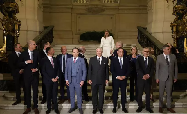 Belgium's new Justice Minister Annelies Verlinden, rear, walks down the steps to join a group photo after a swearing in ceremony for the new government in front of Belgium's King Philippe at the Royal Palace in Brussels, Monday, Feb. 3, 2025. (AP Photo/Omar Havana)