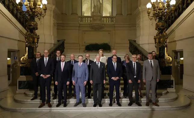 Belgium's King Philippe, center front, and new Belgian Prime Minister Bart De Wever, front center left, pose with ministers for a group photo after a swearing in ceremony for the new government at the Royal Palace in Brussels, Monday, Feb. 3, 2025. (AP Photo/Omar Havana)