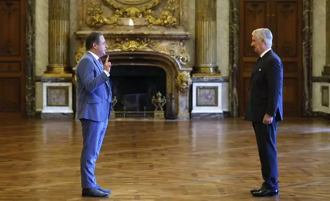 New Belgian Prime Minister Bart De Wever, left, raises his hand to take an oath during a swearing in ceremony for the new government in front of Belgium's King Philippe at the Royal Palace in Brussels, Monday, Feb. 3, 2025. (AP Photo/Omar Havana)