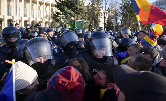 Riot police scuffle with supporters of Calin Georgescu, the winner of Romania's first round of presidential election which the Constitutional Court later annulled, who broke through police lines in front of the government headquarters, in Bucharest, Romania, Monday, Feb. 10, 2025. (AP Photo/Vadim Ghirda)