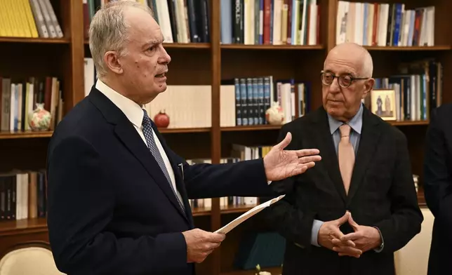 The newly elected President of Parliament, Constantine Tassoulas, left, delivers a speech after receiving the results of the fourth round of voting at the parliament in Athens, Greece, Wednesday, Feb. 12, 2025. (Angelos Tzortzinis/Pool Photo via AP)