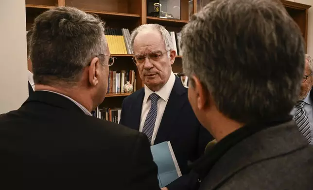 Newly elected President of Parliament, Constantine Tassoulas, center, talks with his associates after the results of the fourth round of voting at the parliament building in Athens, Greece, on Wednesday, Feb. 12, 2025. (Angelos Tzortzinis/Pool Photo via AP)