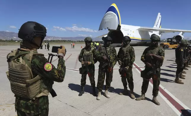 Members of the Kenyan police, who are part of a UN-backed multinational force, pose for a photo on the tarmac at the Toussaint Louverture International Airport in Port-au-Prince, Haiti, Thursday, Feb. 6, 2025. (AP Photo/Odelyn Joseph)