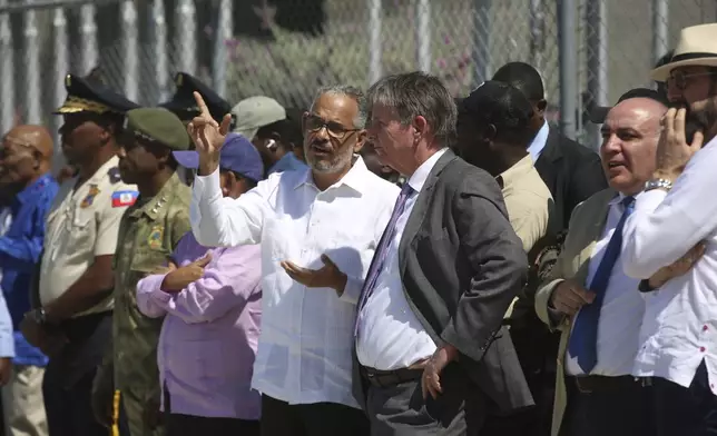 Haitian Prime Minister Alix Didier Fils-Aime, center left, speaks with U.S. Ambassador Dennis B. Hankins, as they wait for the arrival of a Kenyan police contingent, part of a U.N.-backed multinational force, in Port-au-Prince, Haiti, Thursday, Feb. 6, 2025. (AP Photo/Odelyn Joseph)