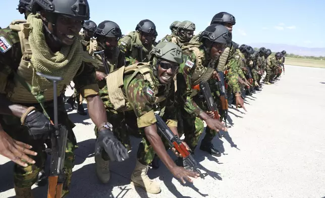 Kenyan police, who are part of a UN-backed multinational force, sing and dance on the tarmac after landing at the Toussaint Louverture International Airport in Port-au-Prince, Haiti, Thursday, Feb. 6, 2025. (AP Photo/Odelyn Joseph)