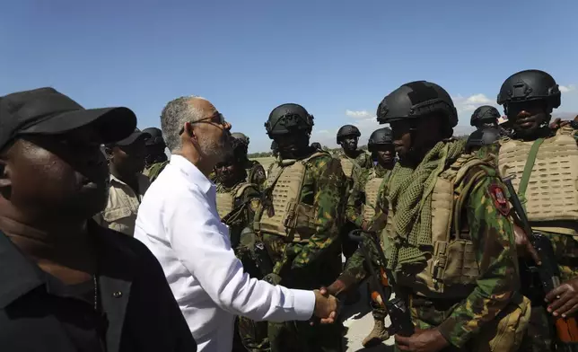 Haitian Prime Minister Alix Didier Fils-Aime, left, greets a member of the U.N.-backed Kenya police force at Toussaint Louverture International Airport, in Port-au-Prince, Haiti, Thursday, Feb. 6, 2025. (AP Photo/Odelyn Joseph)