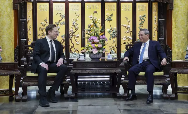 FILE - In this photo released by Xinhua News Agency, visiting Tesla CEO Elon Musk, left, meets with then-Chinese Premier Li Qiang in Beijing, Sunday, April 28, 2024. (Wang Ye/Xinhua via AP, File)