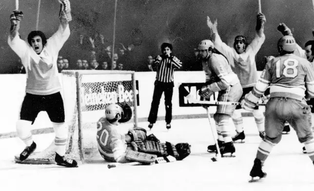 FILE - Team Canada's Phil Esposito, left, raises arms after scoring goal against Soviet Union goalie Vladislav Tretiak, on ice, in final game of series in Moscow, Sept. 28, 1972. Cheering with Esposito are Canada's Ron Ellis, right, and Paul Henderson, third from right. Other Soviets are Vladimir Lutchenko (3) and Vladimir Vikulov (18). (AP Photo/TASS, File)