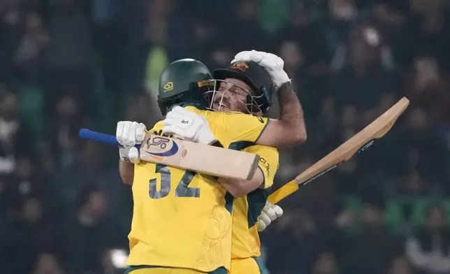 Australia's Josh Inglis is congratulated by teammate Glenn Maxwell after scoring century during the ICC Champions Trophy cricket match between Australia and England, in Lahore, Pakistan, Saturday, Feb. 22, 2025. (AP Photo/K.M. Chaudary)