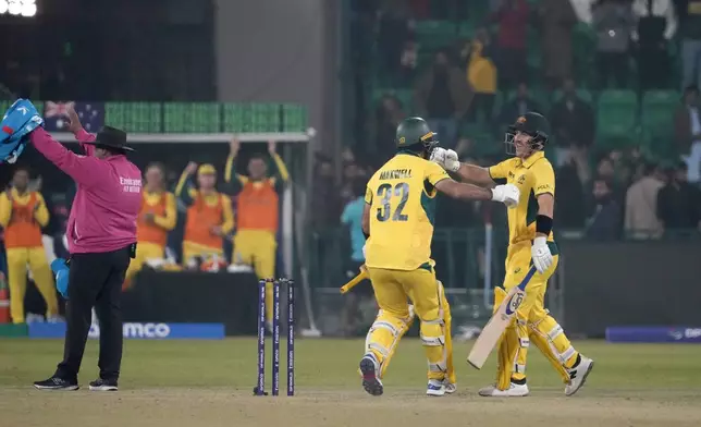 Australia's Josh Inglis, right, celebrates with teammate Glenn Maxwell after playing winning shot during the ICC Champions Trophy cricket match between Australia and England, in Lahore, Pakistan, Saturday, Feb. 22, 2025. (AP Photo/K.M. Chaudary)
