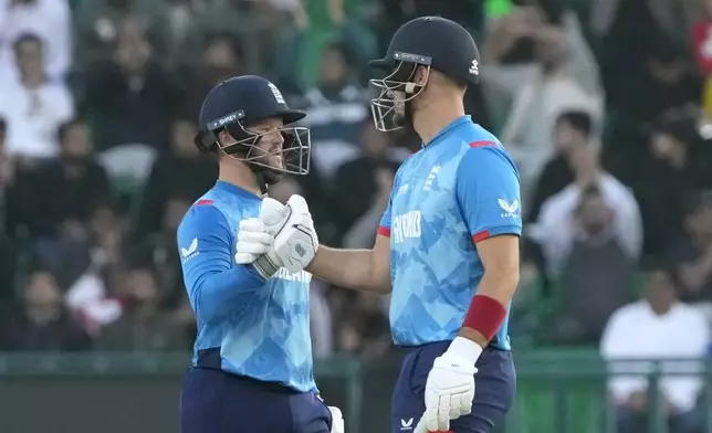 England's Ben Duckett, left, is congratulated by Liam Livingstone after he completing 150 runs during the ICC Champions Trophy cricket match between Australia and England, in Lahore, Pakistan, Saturday, Feb. 22, 2025. (AP Photo/K.M. Chaudary)