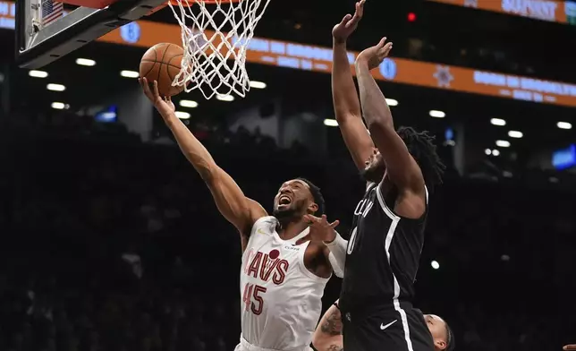 Cleveland Cavaliers' Donovan Mitchell (45) drives past Brooklyn Nets' Day'Ron Sharpe (20) during the first half of an NBA basketball game Thursday, Feb. 20, 2025, in New York. (AP Photo/Frank Franklin II)