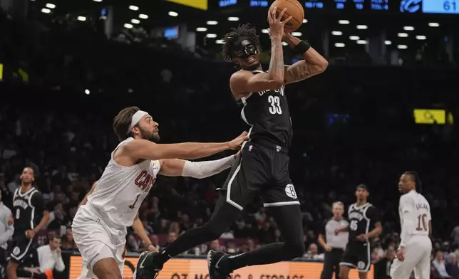 Cleveland Cavaliers' Max Strus (1) defends Brooklyn Nets' Nic Claxton (33) during the second half of an NBA basketball game Thursday, Feb. 20, 2025, in New York. (AP Photo/Frank Franklin II)