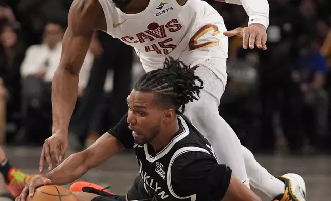 Cleveland Cavaliers' Donovan Mitchell (45) fights for control of the ball with Brooklyn Nets' Ziaire Williams (8) during the second half of an NBA basketball game Thursday, Feb. 20, 2025, in New York. (AP Photo/Frank Franklin II)