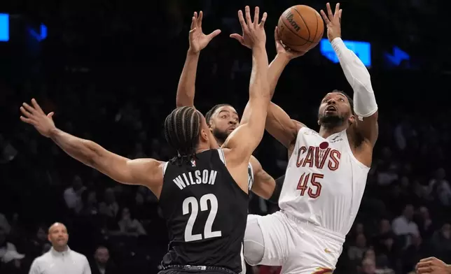 Cleveland Cavaliers' Donovan Mitchell (45) shoots over Brooklyn Nets' Jalen Wilson (22) and Trendon Watford during the first half of an NBA basketball game Thursday, Feb. 20, 2025, in New York. (AP Photo/Frank Franklin II)