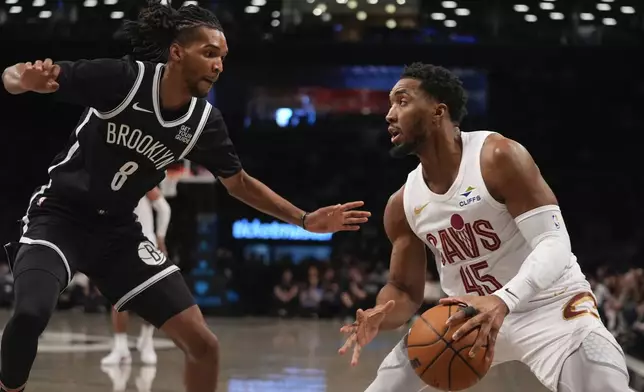 Brooklyn Nets' Ziaire Williams (8) defends Cleveland Cavaliers' Donovan Mitchell (45) during the first half of an NBA basketball game Thursday, Feb. 20, 2025, in New York. (AP Photo/Frank Franklin II)