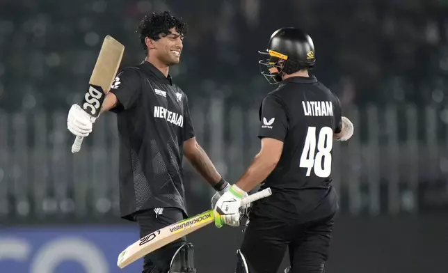 New Zealand's Rachin Ravindra, left, celebrates with teammate Tom Latham after scoring century during the ICC Champions Trophy cricket match between Bangladesh and New Zealand, in Rawalpindi, Pakistan Monday, Feb. 24, 2025,. (AP Photo/Anjum Naveed)