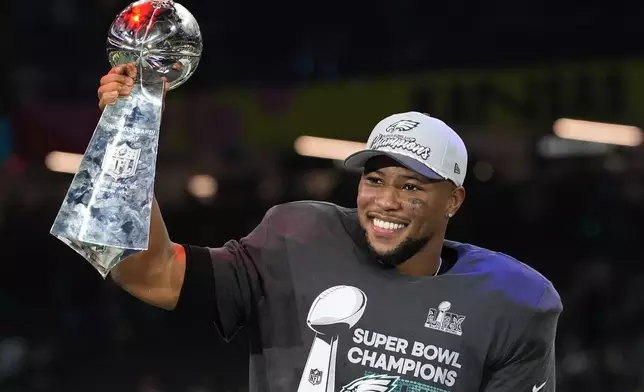 Philadelphia Eagles running back Saquon Barkley celebrates with the Vince Lombardi Trophy after the NFL Super Bowl 59 football game against the Kansas City Chiefs, Sunday, Feb. 9, 2025, in New Orleans. (AP Photo/Brynn Anderson)
