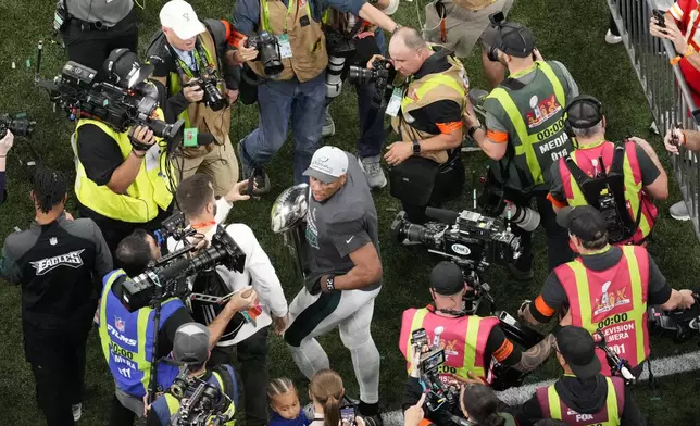 Philadelphia Eagles running back Saquon Barkley carries the Vince Lombardi Trophy after the Eagles won the NFL Super Bowl 59 football game against the Kansas City Chiefs, Sunday, Feb. 9, 2025, in New Orleans. (AP Photo/David J. Phillip)