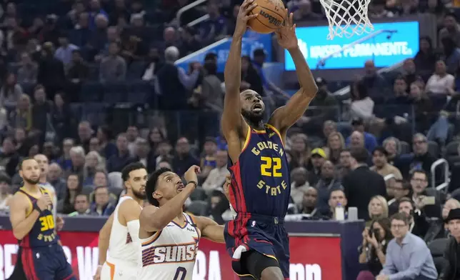 Golden State Warriors forward Andrew Wiggins (22) shoots against Phoenix Suns forward Ryan Dunn (0) during the first half of an NBA basketball game in San Francisco, Friday, Jan. 31, 2025. (AP Photo/Jeff Chiu)