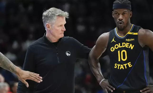 Golden State Warriors head coach Steve Kerr, left, pats Warriors forward Jimmy Butler (10) on the back during the first half of an NBA basketball game against the Chicago Bulls, Saturday, Feb. 8, 2025, in Chicago. (AP Photo/Erin Hooley)
