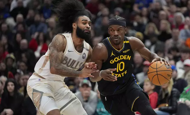 Chicago Bulls guard Coby White, left, guards against Golden State Warriors forward Jimmy Butler (10) during the second half of an NBA basketball game Saturday, Feb. 8, 2025, in Chicago. (AP Photo/Erin Hooley)