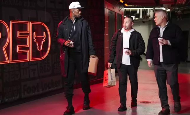 Golden State Warriors forward Jimmy Butler, left, arrives before an NBA basketball game against the Chicago Bulls, Saturday, Feb. 8, 2025, in Chicago. (AP Photo/Erin Hooley)