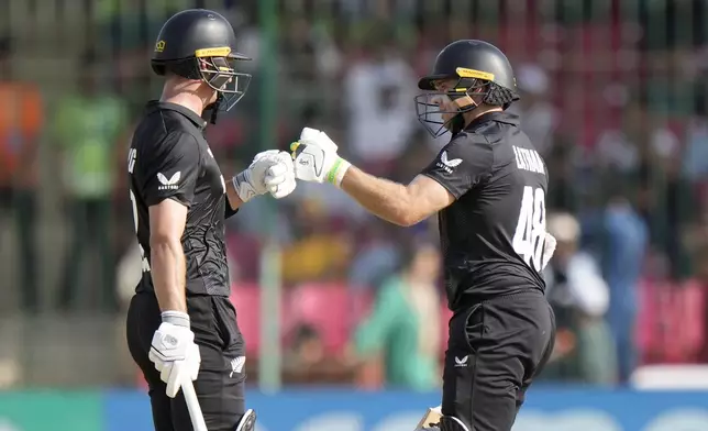 New Zealand's Tom Latham, right, celebrates with Will Young after hitting a boundary during the ICC Champions Trophy cricket match between Pakistan and New Zealand, in Karachi, Pakistan Wednesday, Feb. 19, 2025. (AP Photo/Anjum Naveed)