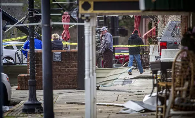 Emergency personnel and others survey damage from severe weather near the intersection of Main and Fifth Streets in downtown Tuscumbia, Ala., Sunday, Feb. 16, 2025.(Dan Busey/The TimesDaily via AP)