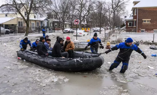 Members of the Southeast Michigan Dive Team pull people to safety after a water main break in Detroit caused massive flooding, triggering evacuations, Monday, Feb. 17, 2025. (Andy Morrison/Detroit News via AP)