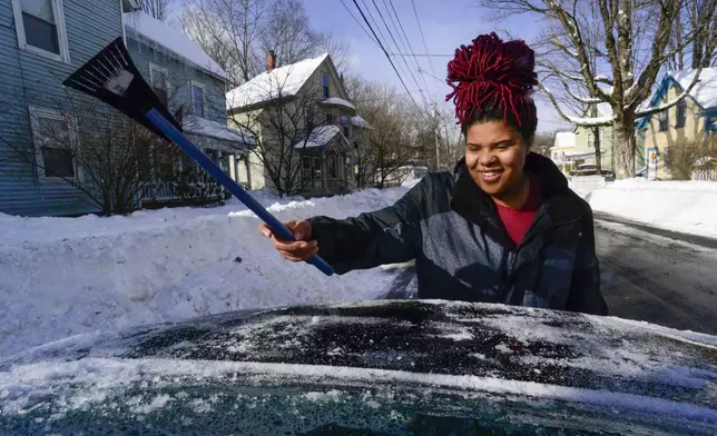 Trinity Jackson uses an ice scraper to clean her rear window on Monday, Feb. 17, 2025, Brattleboro, Vt., after a winter storm on Sunday. (Kristopher Radder/The Brattleboro Reformer via AP)
