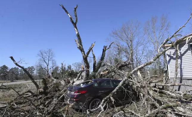 A car sits destroyed under the debris of a tree from severe weather along Lee County Rd 154 in Shannon, Miss. ,Monday, Feb. 17, 2025. (Thomas Wells/The Northeast Mississippi Daily Journal via AP)
