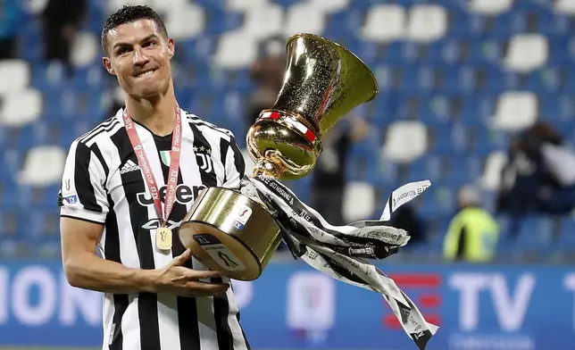 FILE - Juventus' Cristiano Ronaldo celebrates with the winner's trophy a victory against Atalanta after the end of Italian Cup soccer final match between Atalanta and Juventus at the Mapei Stadium in Reggio Emilia, Italy, Wednesday, May 19, 2021. (AP Photo/Antonio Calanni, File)