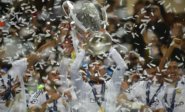 FILE - Real's Cristiano Ronaldo, centre, lifts the Champion League trophy, at the end of the Champions League final soccer match between Atletico Madrid and Real Madrid, at the Luz stadium, in Lisbon, Portugal, Saturday, May 24, 2014. (AP Photo/Manu Fernandez, File)