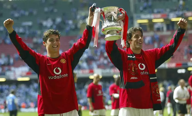 FILE - Manchester United's Cristino Ronaldo, left, holds the trophy aloft with teammate Ruud van Nistelrooy at the end of the FA Cup final between Millwall and Manchester United at the Millennium Stadium in Cardiff, Wales, Saturday, May 22, 2004. (AP Photo/Alastair Grant, File, File)