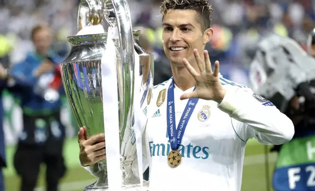 FILE - Real Madrid's Cristiano Ronaldo celebrates with the trophy after winning the Champions League Final soccer match between Real Madrid and Liverpool at the Olimpiyskiy Stadium in Kiev, Ukraine, Saturday, May 26, 2018. (AP Photo/Pavel Golovkin, File)
