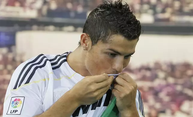 FILE - Real Madrid's new soccer player Cristiano Ronaldo from Portugal kisses his jersey during his presentation at the Santiago Bernabeu stadium in Madrid on Monday, July 6, 2009. (AP Photo/Victor R. Caivano, File)