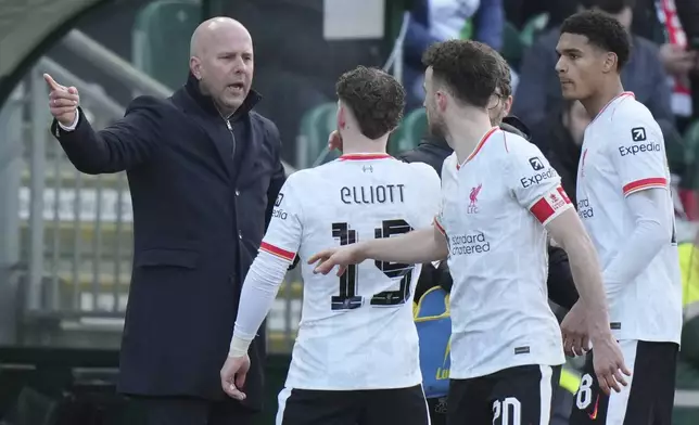 Liverpool's manager Arne Slot, left gestures as he speaks to his players Liverpool's Harvey Elliott, Liverpool's Diogo Jota during the English FA Cup fourth round soccer match between Plymouth Argyle and Liverpool at Home Park stadium in Plymouth, England, Sunday, Feb. 9, 2025. (AP Photo/Alastair Grant)