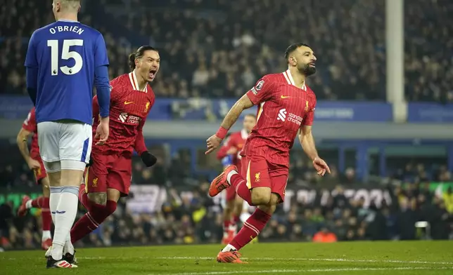 Liverpool's Mohamed Salah, right, celebrates after scoring his side's second goal during the English Premier League soccer match between Everton and Liverpool, Liverpool, England, Wednesday, Feb.12, 2025. (AP Photo/Dave Thompson)