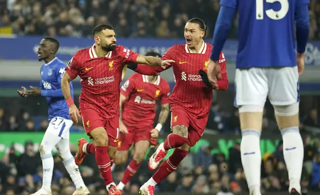Liverpool's Mohamed Salah, centre, celebrates after scoring his side's second goal during the English Premier League soccer match between Everton and Liverpool, Liverpool, England, Wednesday, Feb.12, 2025. (AP Photo/Dave Thompson)